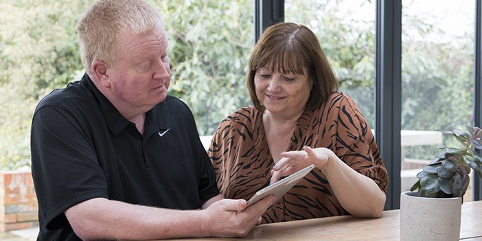 A volunteer helping someone with an iPad.