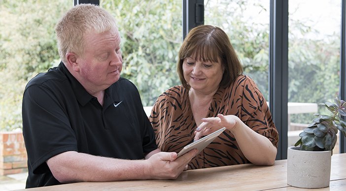 A volunteer helping someone with an iPad.