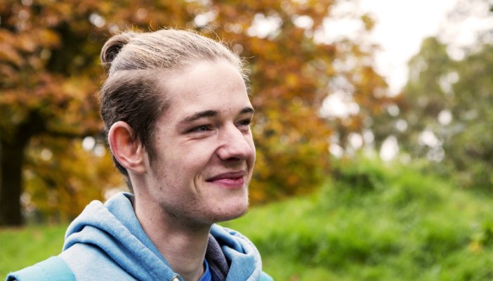 A smiling young man outside