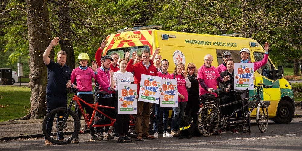 RNIB Volunteers standing in front of an ambulance with bicycles and signs that read "The Big Help Out"