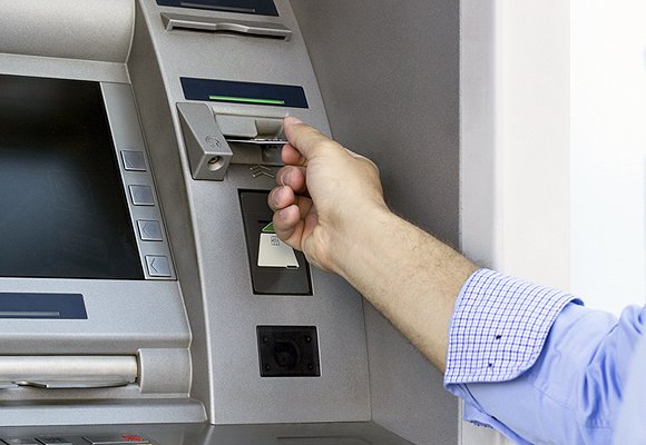 A man inserting a bank card into a cashpoint machine.