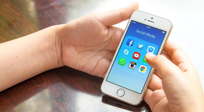 A person uses social media on their smartphone