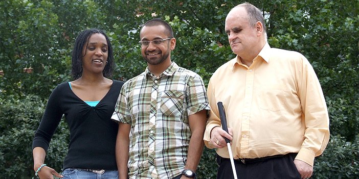 Image of three people with sight loss, one holding a white cane.