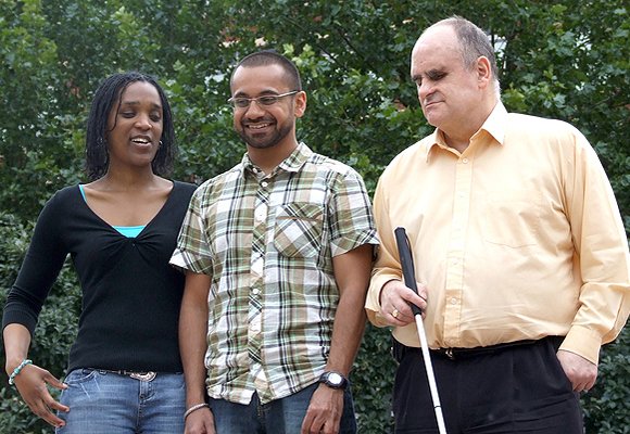 Image of three people with sight loss, one holding a white cane.