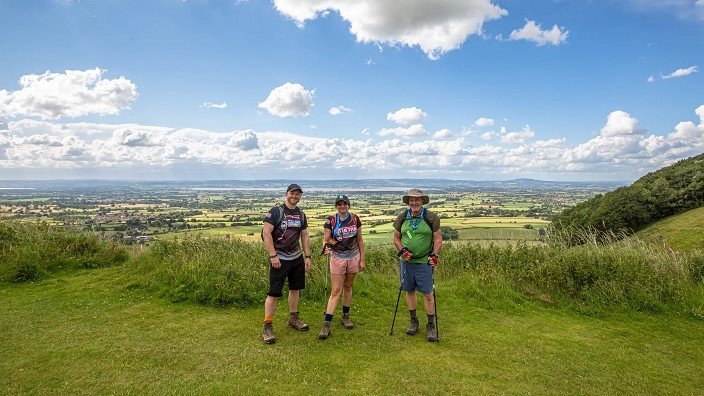 Image of Kent Downs Challenge participants posing for a photo opportunity mid-trek amidst the stunning Kent countryside.