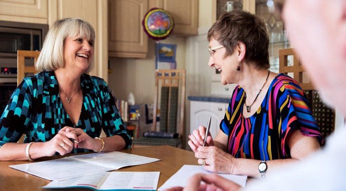 A couple at home speaking with a casual advisor