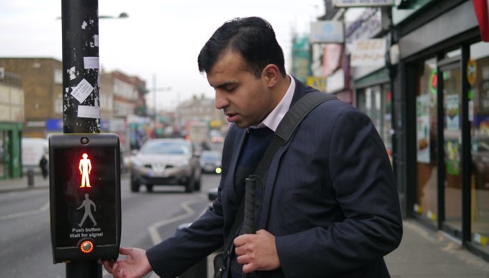 A man using the visual cue guide at a pedestrian crossing.