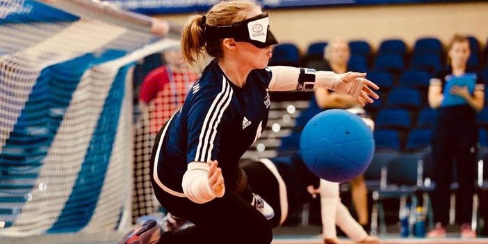 Girl stopping ball going into goal in a sports centre