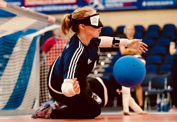 Girl stopping ball going into goal in a sports centre