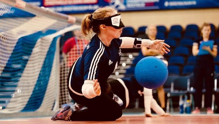Girl stopping ball going into goal in a sports centre