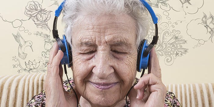 A lady wearing headphones with eyes closed in enjoyment.