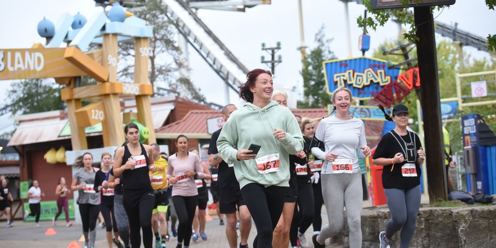 Runners at the Thorpe Park 10k event running past the Tidal Wave ride and Angry Birds land.