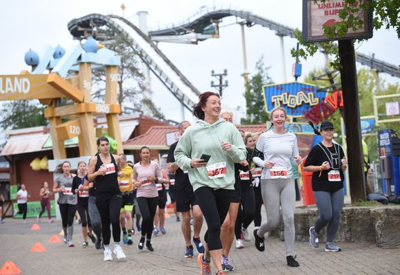 Runners at the Thorpe Park 10k event running past the Tidal Wave ride and Angry Birds land.