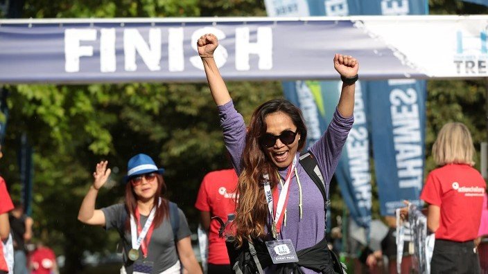 Image of a jubilant participant of the Thames Bridges Trek crossing the finish line.