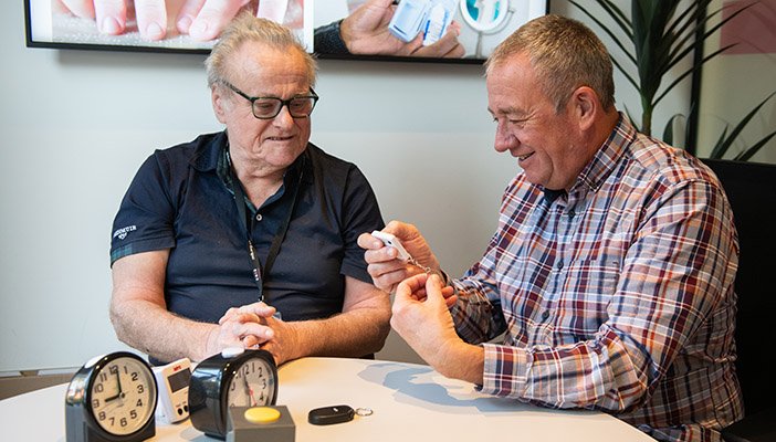 Two men (Dave and Joe) sitting at a small, round table having a light-hearted conversation.