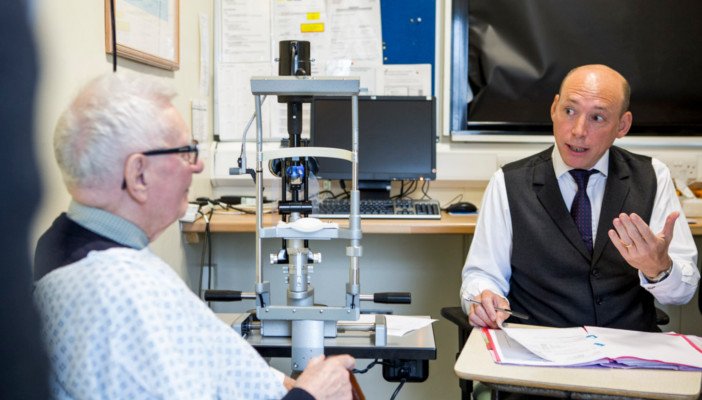 Older man discussing his eye examination with an eye care professional