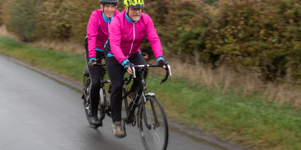 Two men riding a tandem bike