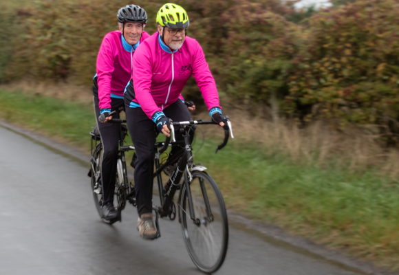 Two men riding a tandem bike