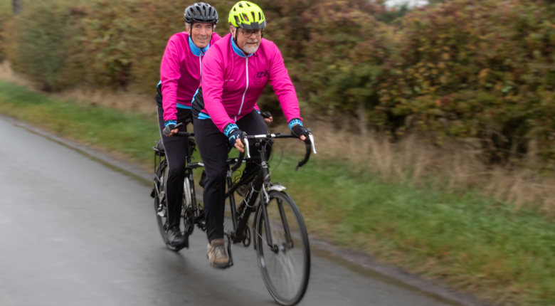 Two men riding a tandem bike
