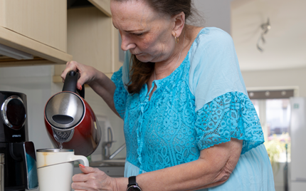 Natalie pouring water into a cup from a kettle.