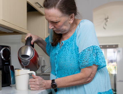 Natalie pouring water into a cup from a kettle.