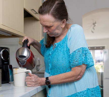 Natalie pouring water into a cup from a kettle.