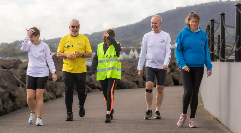 Three women and two men walking in a group